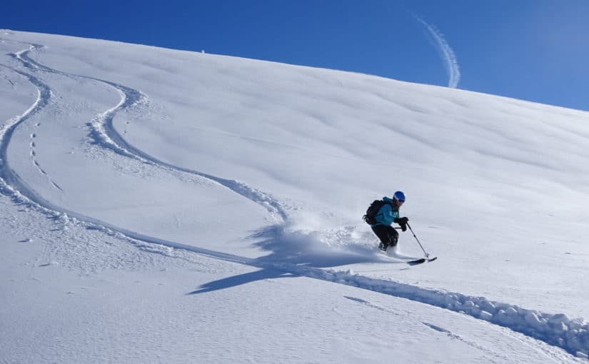 skiier making s curves down the hill