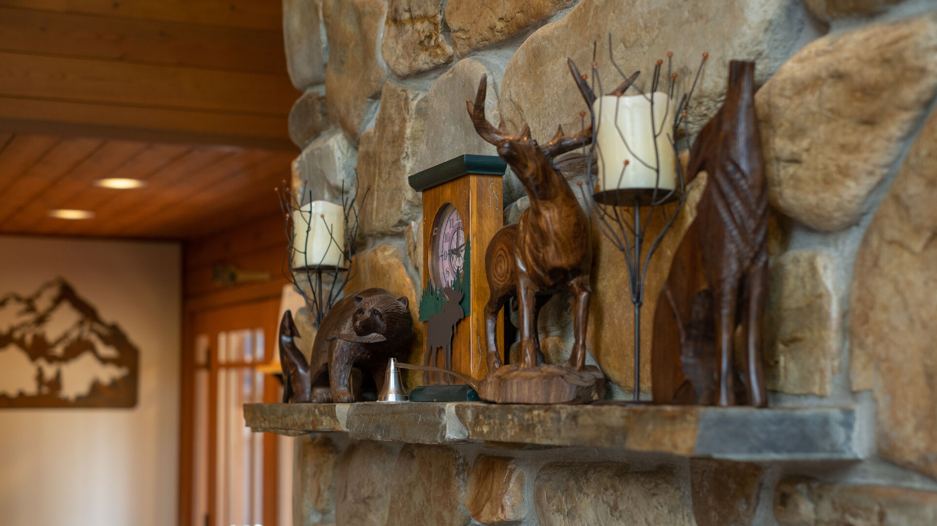 A wooden carved bear and moose on the mantle