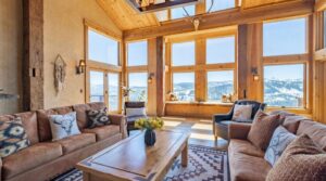 Wide windows highlight a living room with couches and coffee table