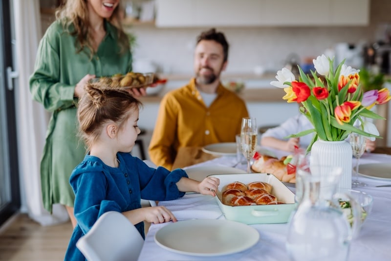 family sitting around a table celebrating Easter with a brunch at home - bright photo with family time