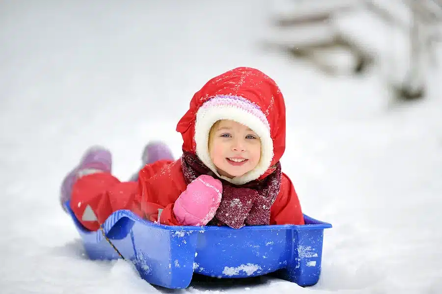 child on a sled in the snow