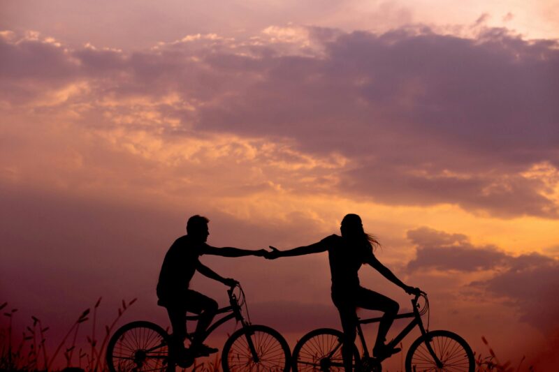 silhouette of a couple riding bikes against sunset