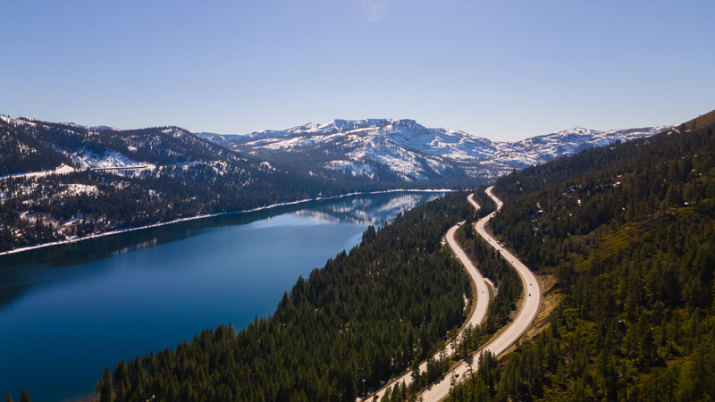 road through the trees with snow visible in North Lake Tahoe