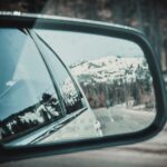 looking into the rearview mirror of a car at a snow-covered hill while driving in North Lake Tahoe