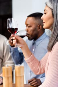 black man and older woman tasting red wine