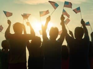 silhouettes of people holding American flags - labor day