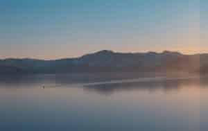 View of Lake Tahoe in the fall with a single boat going across the lake 