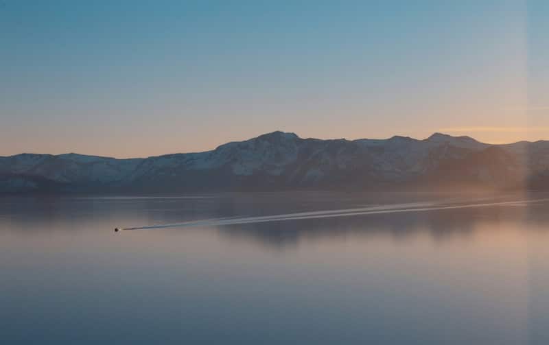 View of Lake Tahoe in the fall with a single boat going across the lake