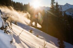 snowboarder jumping on a downhill at sunrise