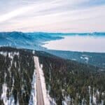 Aerial of Lake Tahoe in the Sierra Nevada of the United States next to a snow-covered sparse forest