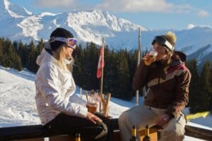 two female snowboarders enjoying apres after a day on the mountain