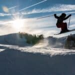 skiier jumping with the sun in the background