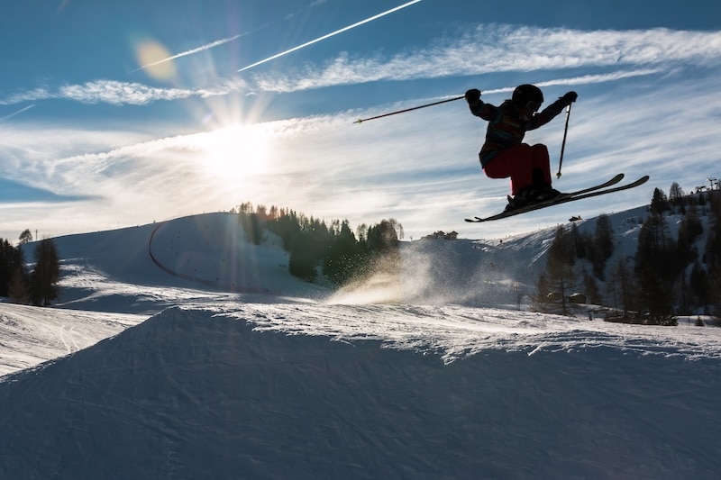skiier jumping with the sun in the background