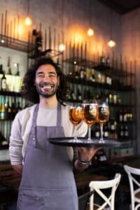 smiling waiter holding a tray of drinks