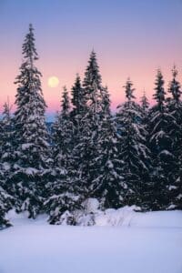full moon over snowy landscape in the mountains