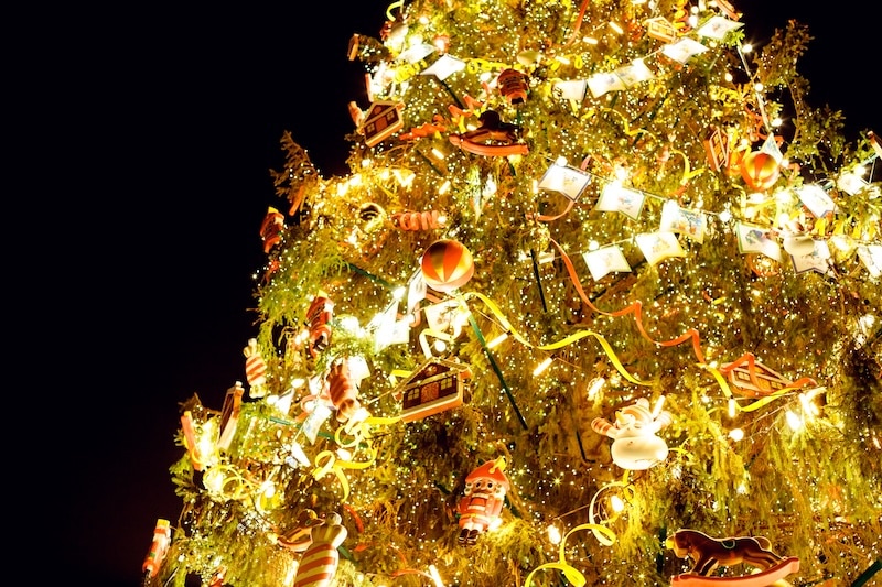 Vintage Christmas Tree with richly decorations.Christmas ornament hanging on tree branch. Shining garland golden lights. retro toys and light garland on Christmas tree. Greeting card
