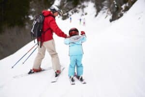 Mother and son on skis, rear view