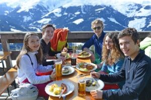 teenagers-enjoying-soft-drinks-and-lunch-on-skiing