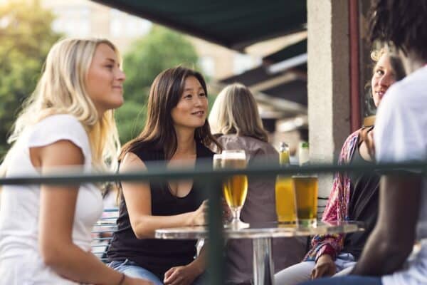 Friends having beer in sidewalk cafe