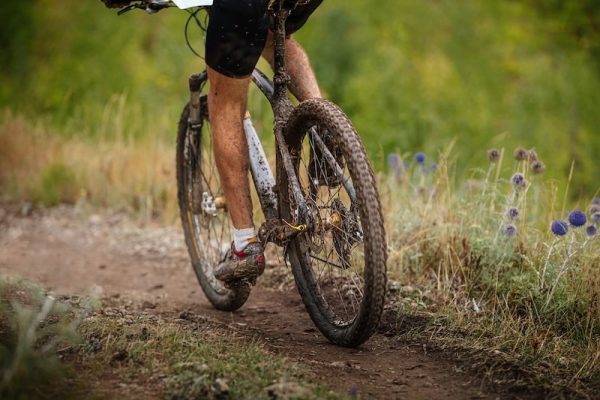 dirty feet and mountain bike male athlete mountainbiker. riding on forest trail. cross-country cycling race